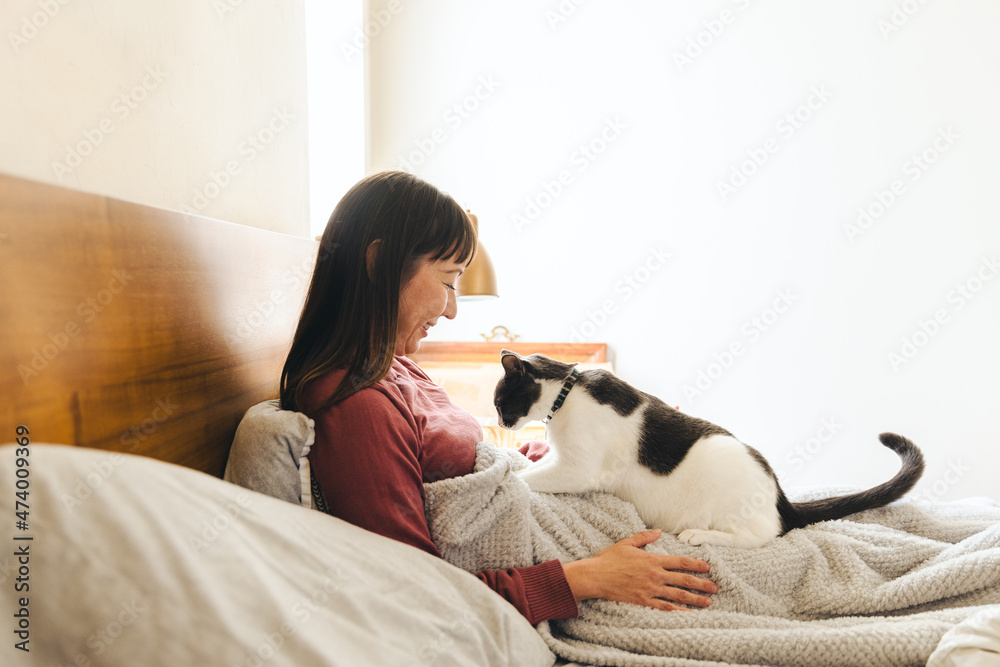 Happy Woman With Playful Cat On Bed