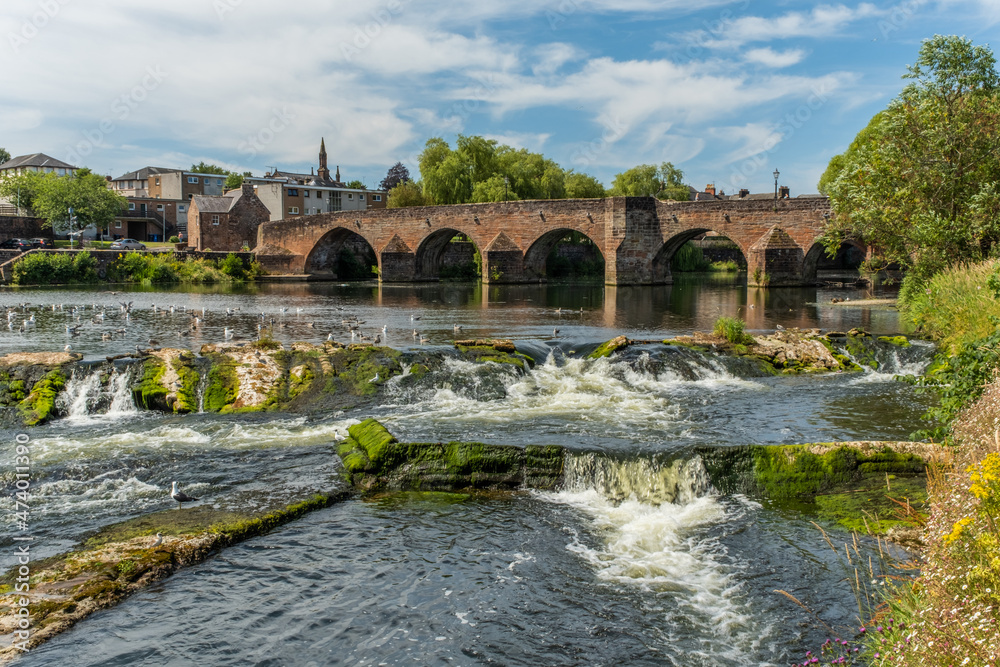 The River Nith flowing over the Caul weir in Dumfries, during summer in Scotland