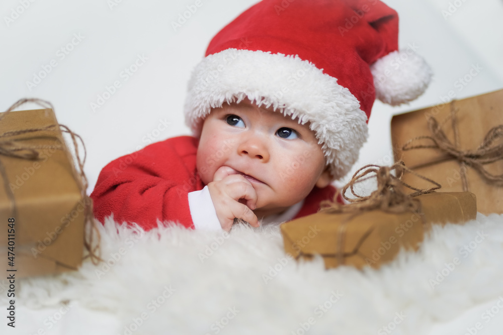 happy newborn baby in santa claus outfit with eco friendly natural paper gift box for christmas lying on white background
happy newborn baby in santa claus outfit with eco friendly natural paper gift box for christmas lying on white background