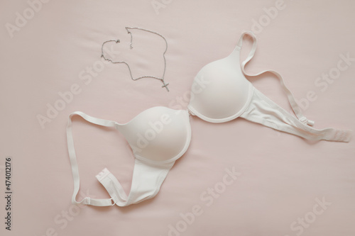 female white lace bra with jewelry on beige background