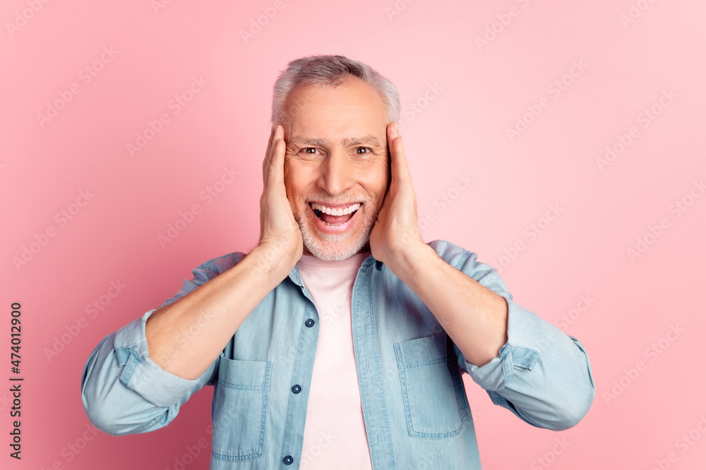 Photo of aged excited man arms touch face unexpected good news discount isolated over pink color background Photo of aged excited man arms touch face unexpected good news discount isolated over pink color background
