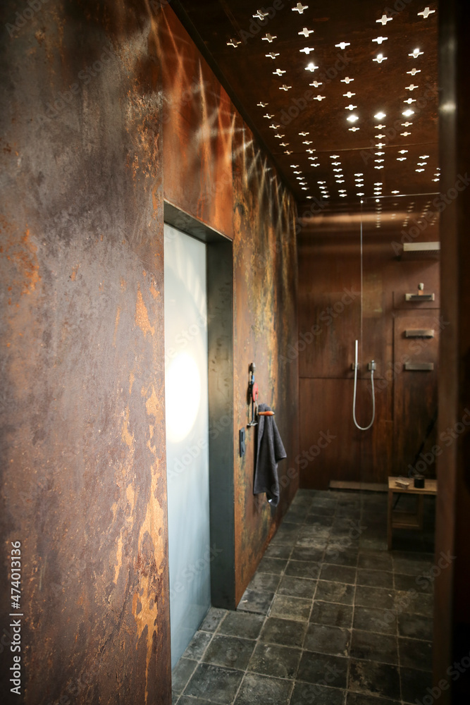 Modern bathroom with corten steel wall cladding and ceiling light effects Modern bathroom with corten steel wall cladding and ceiling light effects