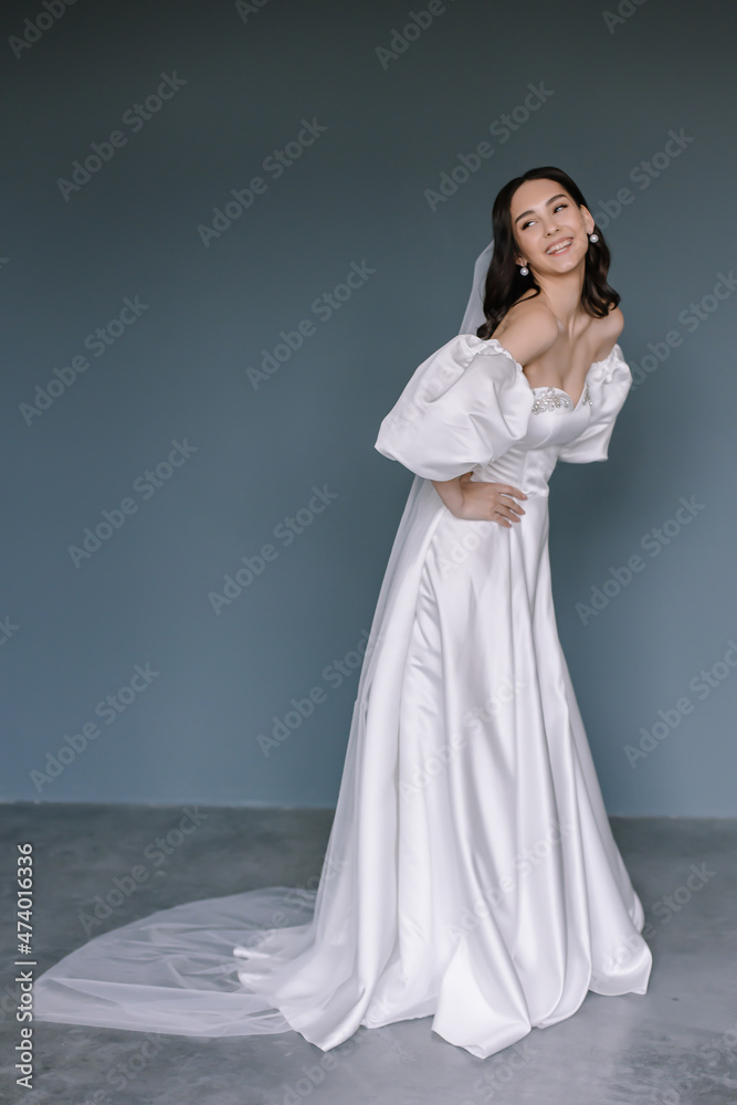 Beautiful bride in a white dress posing at the camera Portrait of a brunette woman Beautiful bride in a white dress posing at the camera Portrait of a brunette woman