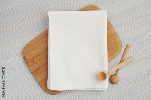 White blank cotton kitchen towel mockup for design presentation, wooden spoons and cutting board. photo