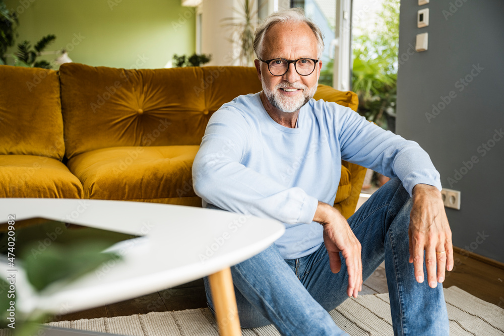 Man smiling while sitting in living room Man smiling while sitting in living room