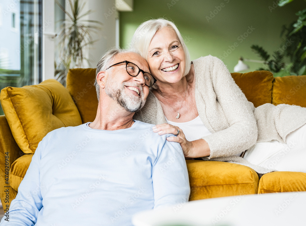 Smiling mature woman leaning on man while resting on sofa Smiling mature woman leaning on man while resting on sofa