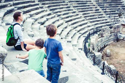 Valokuva mother with little sons on vacation visiting ancient colosseum, summer tourism,