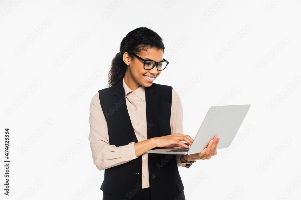 Smiling african american businesswoman using laptop isolated on white. Smiling african american businesswoman using laptop isolated on white.