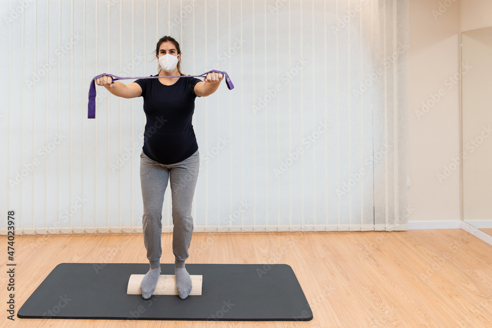 Fototapeta premium pregnant woman on a proprioceptive trunk for rehabilitation of lumboabdominal and perineal walls with , physiotherapist,