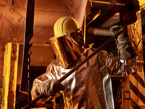 Male worker holding metal rod in foundry photo