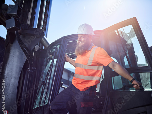 Austria, Tyrol, Brixlegg, Construction worker wearing reflecting clothing and hardhat standing by vehicle photo