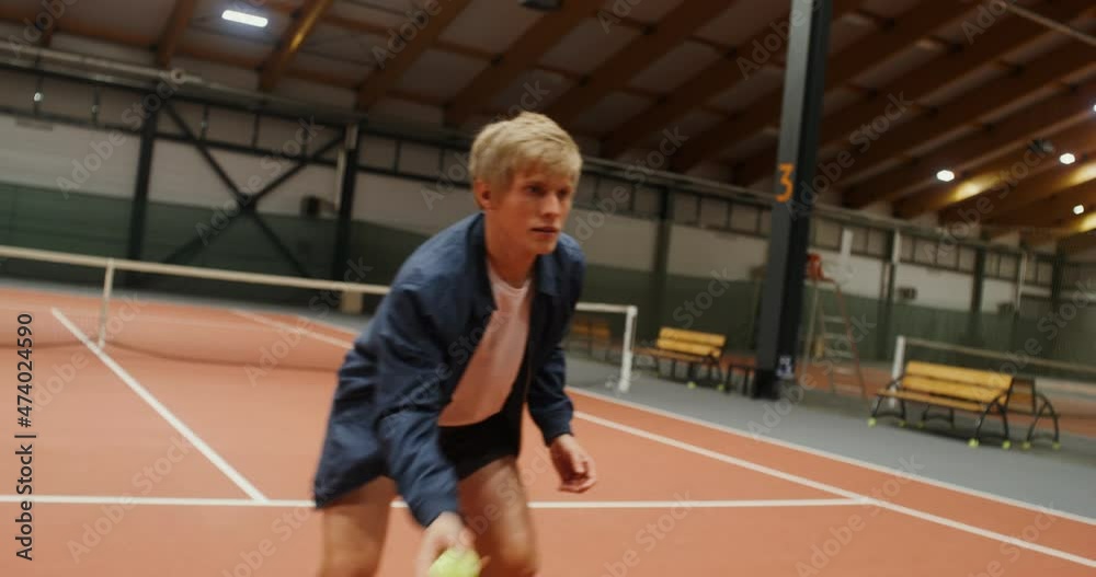 A young man catches tennis balls with his hands one by one, quickly jumping A young man catches tennis balls with his hands one by one, quickly jumping