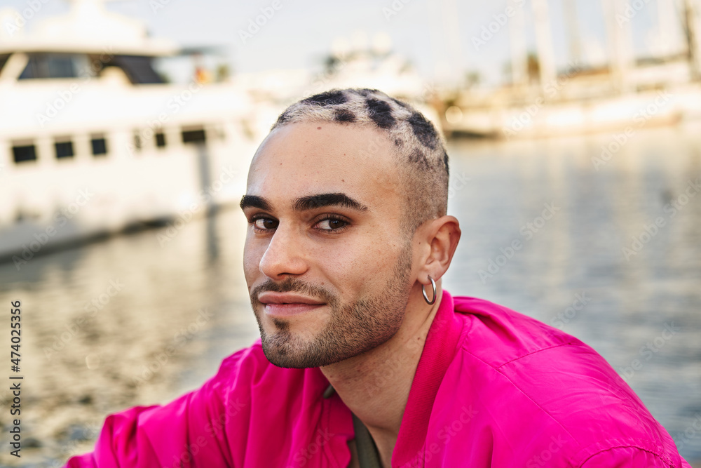 Informal man sitting on harbor with boats