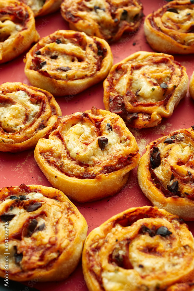 Pizzaschnecken (Fingerfood) auf einer Silikonmatte Pizzaschnecken (Fingerfood) auf einer Silikonmatte