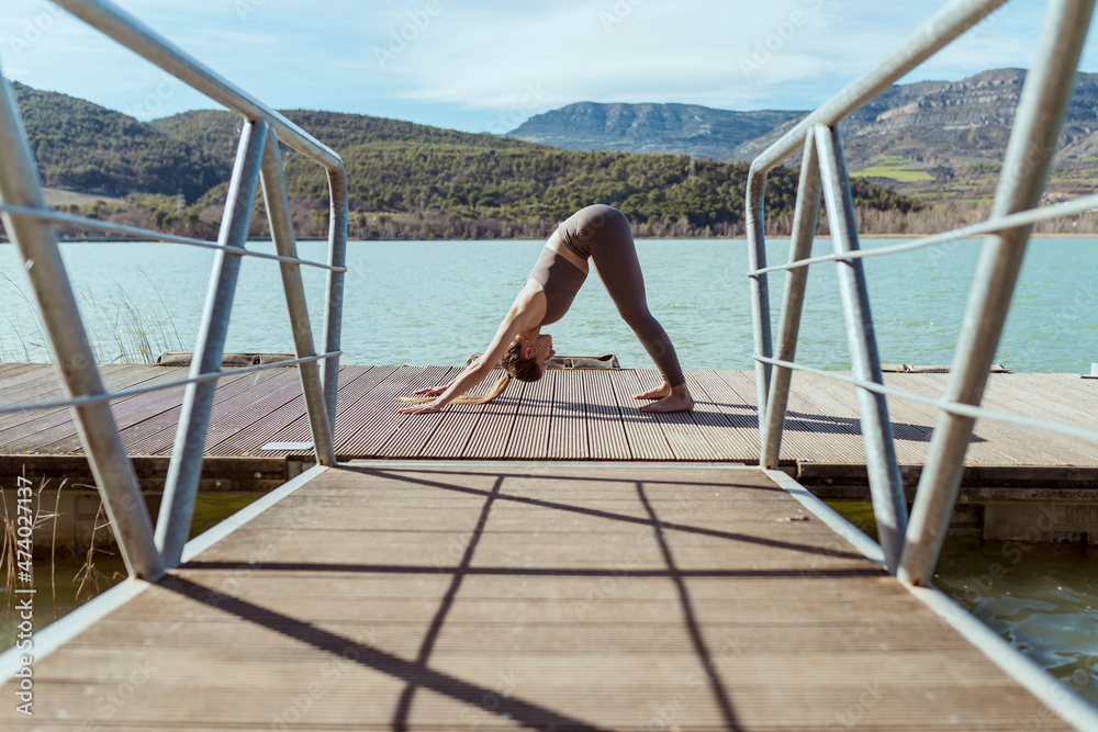 Woman doing yoga on jetty during sunny day Woman doing yoga on jetty during sunny day