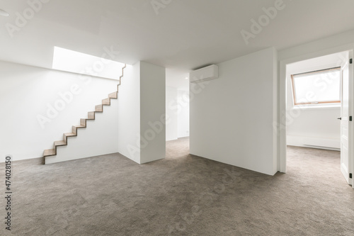 Empty basement space with white walls and concrete floor