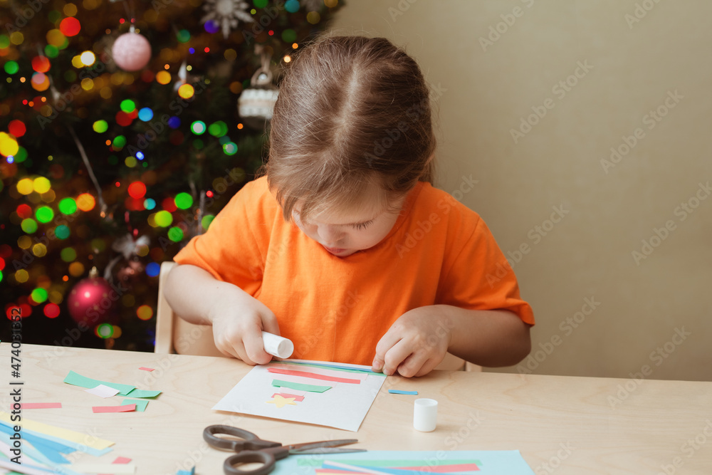 Little Girl Making Christmas Card sitting by table Little Girl Making Christmas Card sitting by table