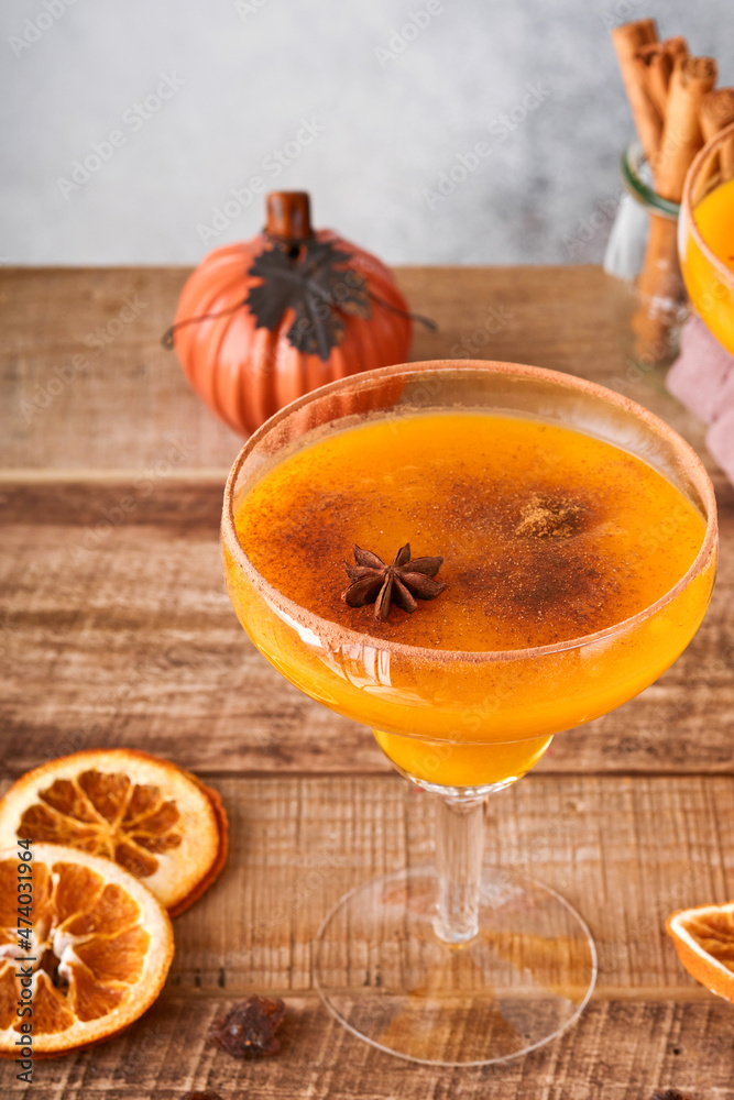 Pumpkin cocktail with cinnamon, orange juice and cocoa in glass mugs. Festive cocktail Halloween margarita. Pumpkin autumn drink for Halloween or Thanksgiving. Pumpkin cocktail with cinnamon, orange juice and cocoa in glass mugs. Festive cocktail Halloween margarita. Pumpkin autumn drink for Halloween or Thanksgiving.