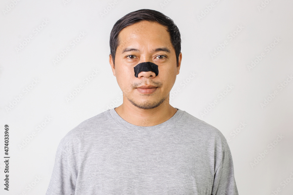 Asian Man Face With Skin Care Patch On Nose. Portrait Of Young Male With Cleansing Pore Strip On Fresh Clean Skin. Closeup Handsome Man With Natural Makeup And Beauty Product. Asian Man Face With Skin Care Patch On Nose. Portrait Of Young Male With Cleansing Pore Strip On Fresh Clean Skin. Closeup Handsome Man With Natural Makeup And Beauty Product.