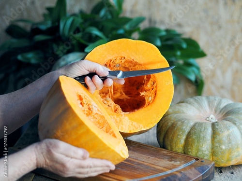 Sliced pumpkin fruit on a wooden ancient table. Pumpkin harvest with seeds. A useful product for the nutrition of diabetics and dieters. photo