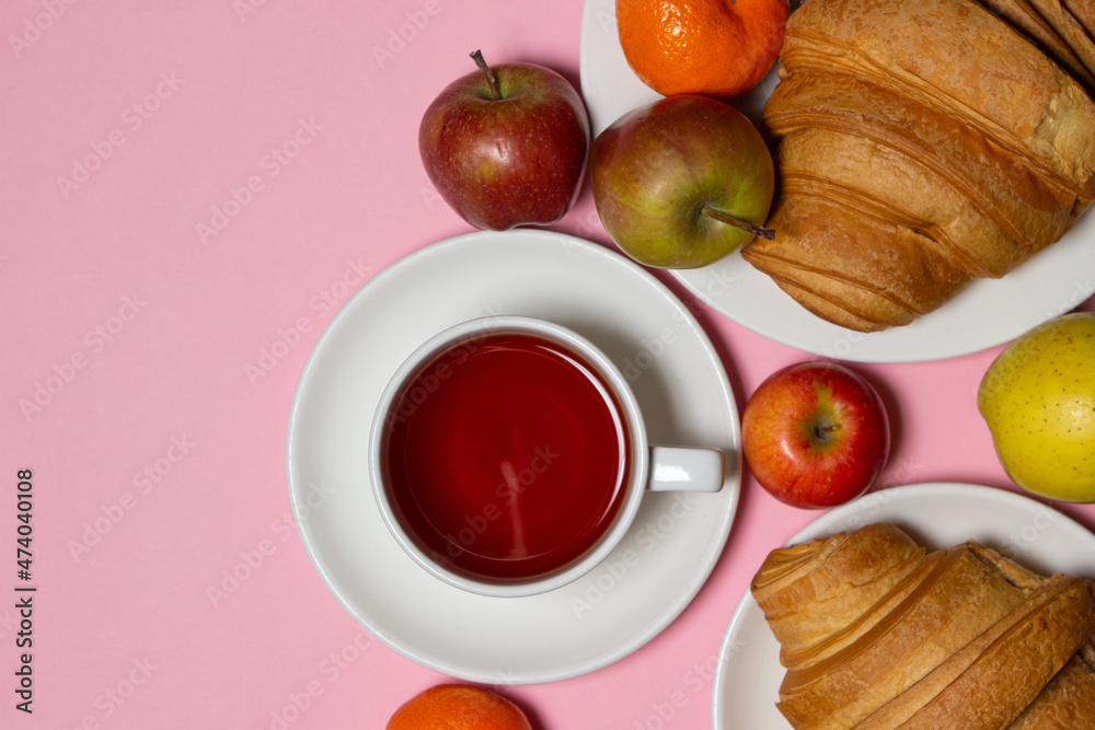 Delicious and healthy breakfast on a pink background. A cup of tea with pastries and fruits. There is room for copy space