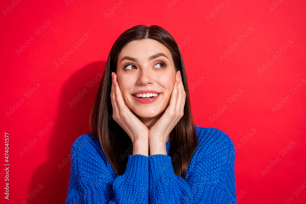 Photo portrait brunette wearing blue sweater touching cheeks smiling looking copyspace isolated on bright red color background Photo portrait brunette wearing blue sweater touching cheeks smiling looking copyspace isolated on bright red color background