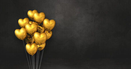 Gold heart shape balloons bunch on a black wall background. Horizontal banner.