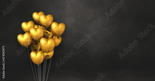 Gold heart shape balloons bunch on a black wall background. Horizontal banner.