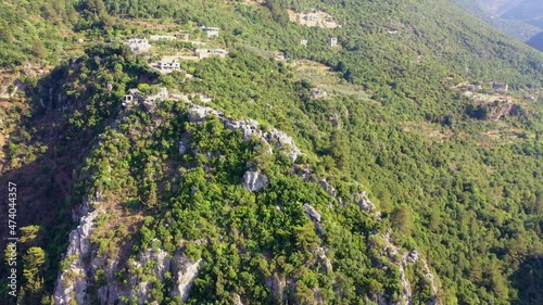 Aerial Panning Beautiful Shot Of Green Natural Rock Formations With Structures On Sunny Day - Yahchouch, Lebanon photo