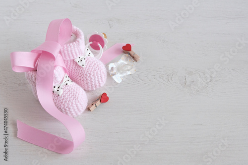 Accessories for children, pink socks, rubber and silicone nipples, pink tape, light background. Attribute of a baby, girls. Copy space