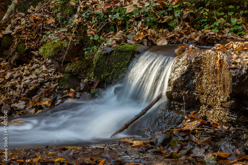 Tranquil waterfall scenery in the middle of autumn forest