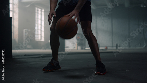 Sportsman legs playing basketball. Afro man hands bouncing basketball ball