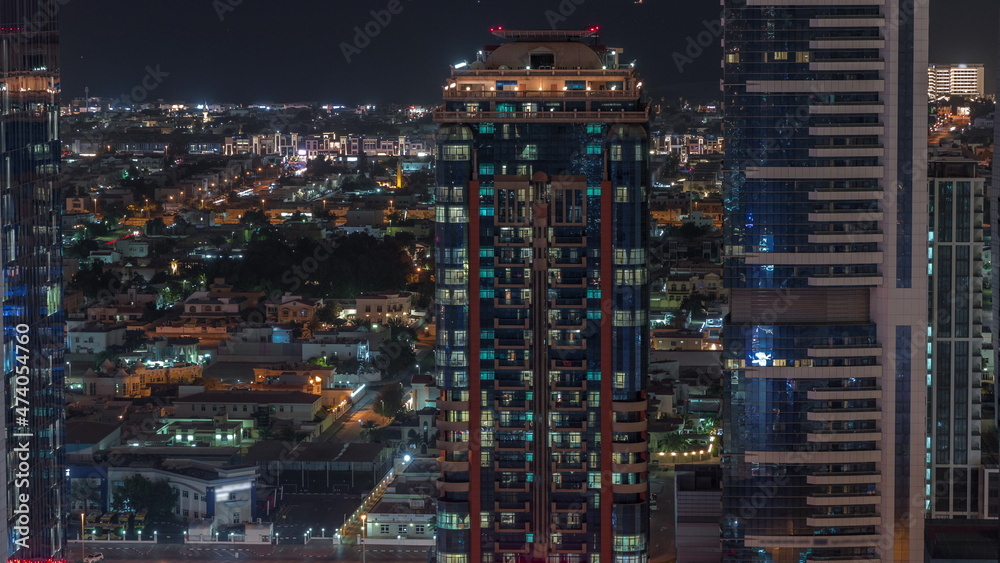 Glowing windows and towers and villa houses on a background aerial night timelapse, Dubai, United Arab Emirates