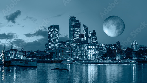 Panorama of the modern skyline on Thames river at twilight blue hour with full moon  - London, United Kingdom "Elements of this image furnished by NASA "