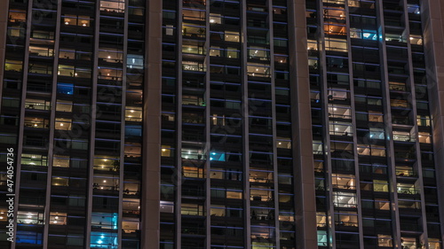 Big glowing windows in modern office and residential buildings timelapse at night
