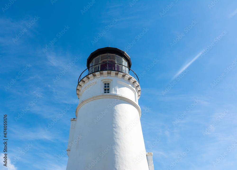 Umpqua lighthouse on Oregon coast, tall white against bright blue skies vertical view. Umpqua lighthouse on Oregon coast, tall white against bright blue skies vertical view.