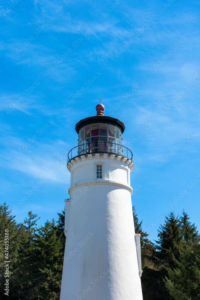 Umpqua lighthouse Oregon coast, tall white against bright blue skies. 