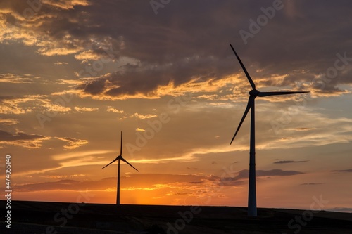 Countryside landscape at sunset with wind turbines in operation