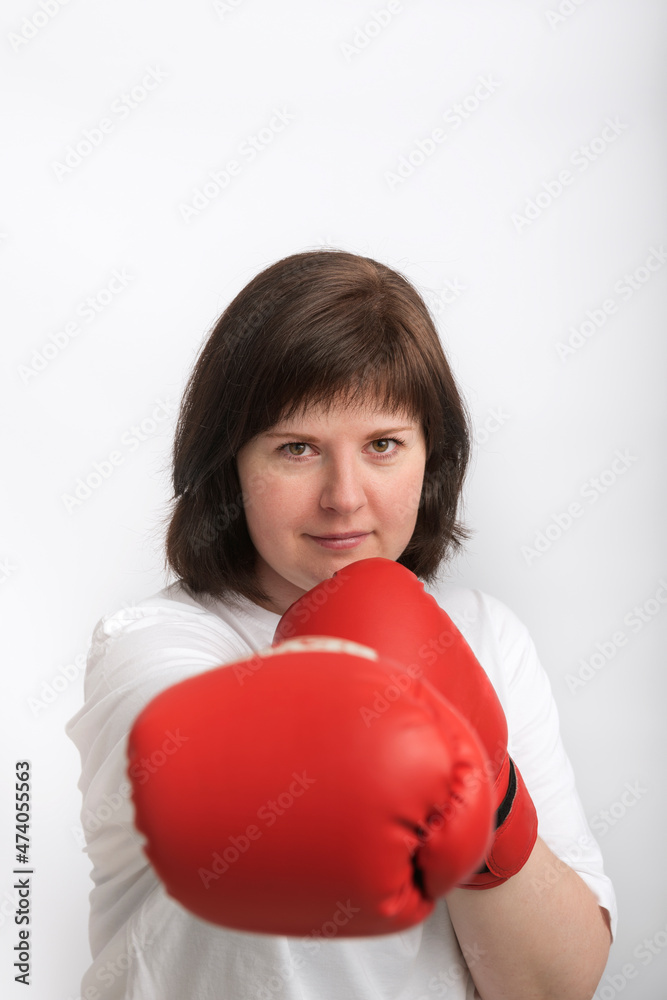 Portrait of confident young woman in boxing gloves on white background. Woman fights for justice. Feminism. Portrait of confident young woman in boxing gloves on white background. Woman fights for justice. Feminism.