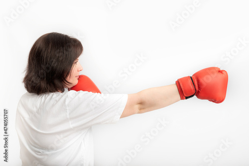 Young woman in boxing gloves on white background. Concept of protection of womens rights. Side view