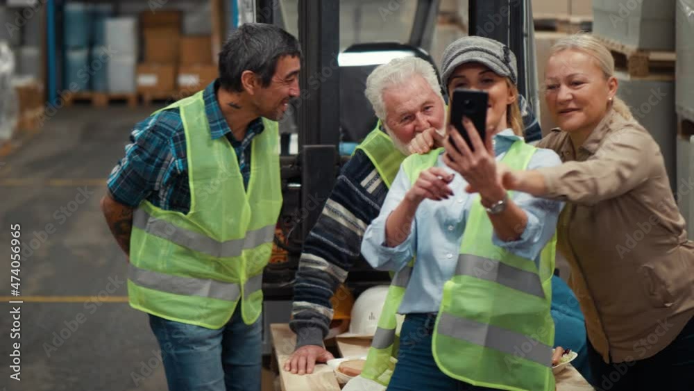 Smiling group of warehouse workers take a selfie photo during a lunch break Smiling group of warehouse workers take a selfie photo during a lunch break