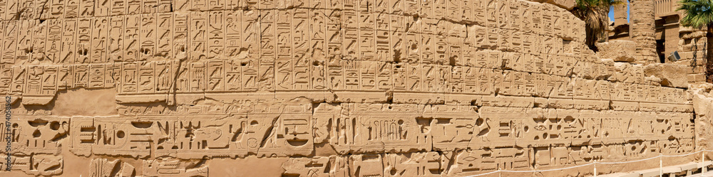 Panoramic view of the wall with Egyptian hieroglyphs and ancient drawings at Karnak Temple. Luxor, Egypt.