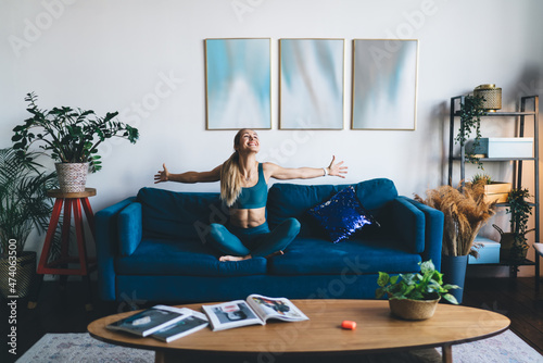 Enjoying european girl sit with open arms on sofa