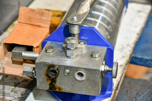 Hydraulic hand pump being repaired in a workshop.