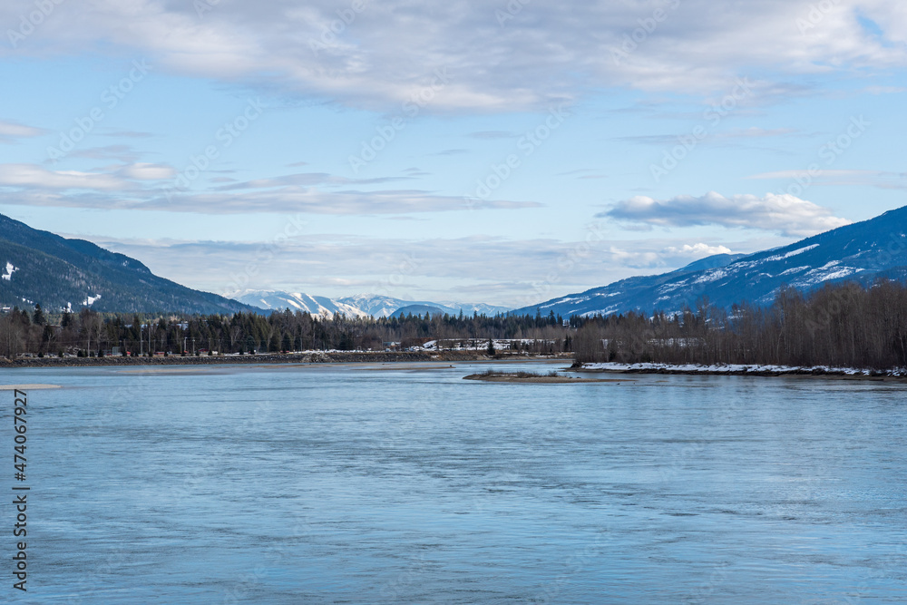 Obraz premium wide Columbia river with snow in mountains blue sky early spring British Columbia Canada