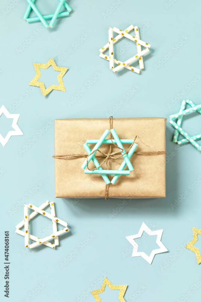 Jewish holiday Hanukkah. A gift and symbol of Hanukkah star of David on a blue background. Top view flat lay. Jewish holiday Hanukkah. A gift and symbol of Hanukkah star of David on a blue background. Top view flat lay.