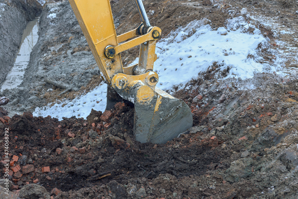 the process of loosening frozen winter soil with an excavator bucket the process of loosening frozen winter soil with an excavator bucket