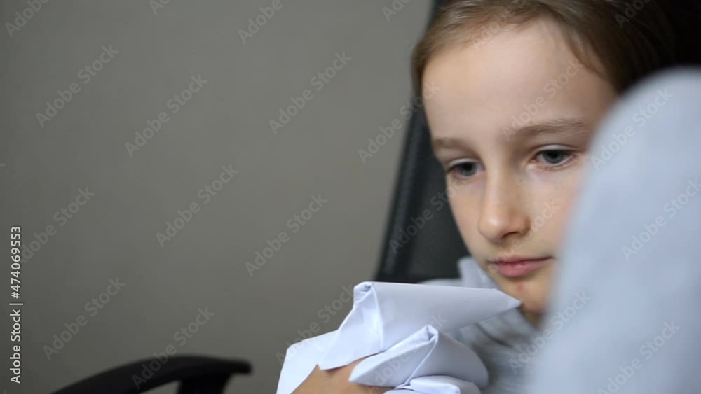 Little blond girl is playing with origami, paper claws of dragon , paper dragons creation, children art concept. Little blond girl is playing with origami, paper claws of dragon , paper dragons creation, children art concept.