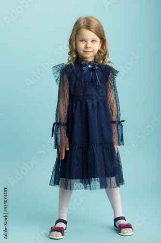 Lovely little girl posing in beautiful blue dress