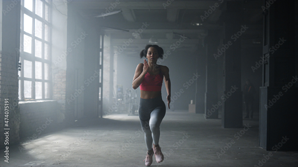 Woman running fast in crossfit gym. Female athlete jogging in sport club Woman running fast in crossfit gym. Female athlete jogging in sport club